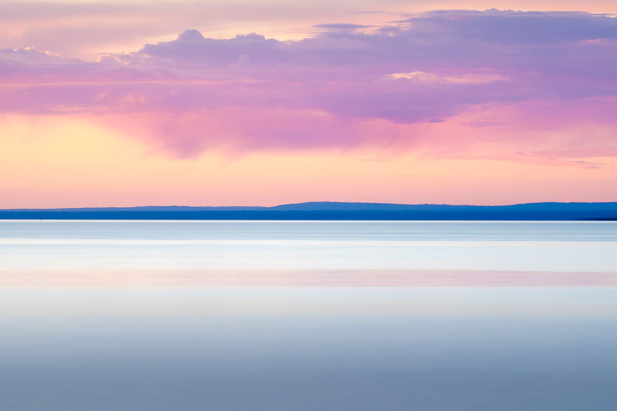 Long exposure of Lake Superior at sunrise with purple rain clouds and pinks and blues