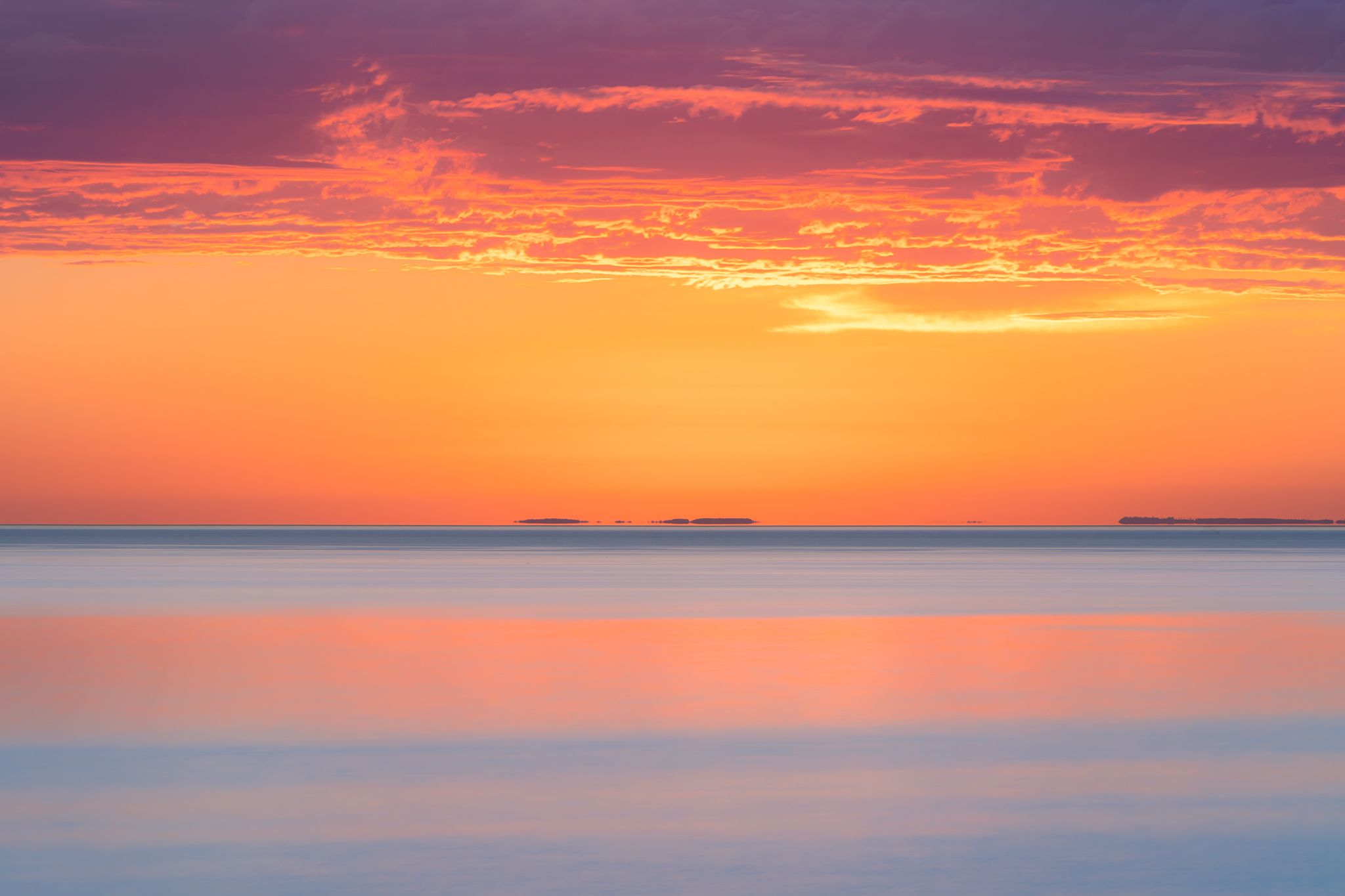 Long exposure of Lake Superior at sunrise with purple rain clouds and pinks and blues