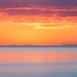 Long exposure of Lake Superior at sunrise with purple rain clouds and pinks and blues